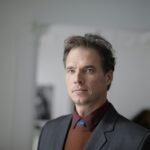 Portrait of a businessman in a formal suit in an indoor setting.